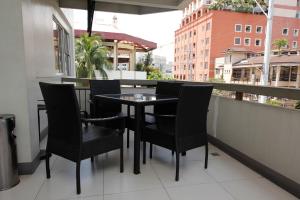 马尼拉卡萨普拉套房酒店的阳台上配有一张黑色的桌子和椅子