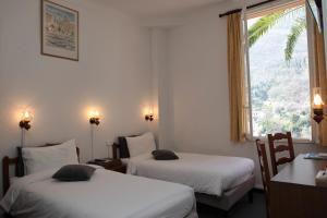 卢河畔图尔雷泰卢河河谷旅馆的酒店客房设有两张床和窗户。