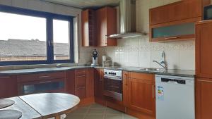 门兴格拉德巴赫Appartement mit Weitblick的厨房配有木制橱柜、桌子和窗户。