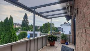 门兴格拉德巴赫Appartement mit Weitblick的一个带盆栽和屋顶的阳台