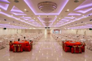 巴淡岛中心Grand Sydney Hotel的一个带红色和白色桌椅的大型宴会厅