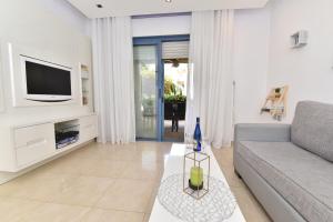 埃拉特Royal Park Eilat - Garden Apartment by CROWN的带沙发和电视的客厅