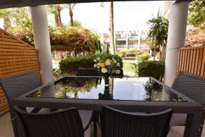 埃拉特Royal Park Eilat - Garden Apartment by CROWN的天井上花瓶的桌子