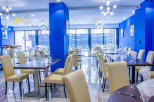 雅温得MERINA HOTEL的一间配备有桌椅的用餐室和蓝色的墙壁