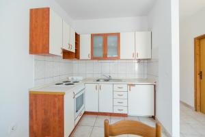 塞尔察Apartments Neva的厨房配有白色橱柜和炉灶烤箱。