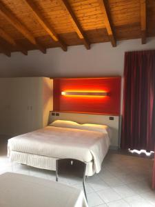 阿尔巴AlbaVillage Hotel & Camping Wellness的一间卧室,上方配有一张红灯床