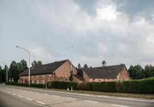 LubbeekCraywinckelhof Streekbelevingscentrum的路边有钟楼的砖砌建筑