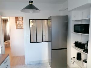 克莱蒙费朗SWEET Appartment avec Wifi et parking的一间厨房,里面配有不锈钢冰箱