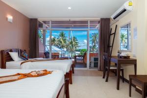 跋麒童瓦兰@塔莱沙酒店的酒店客房设有两张床、一张书桌和一个窗户。