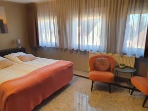 尼乌弗利特Hotel Maurice的酒店客房带一张床、椅子和窗户