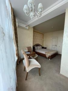 克拉斯诺达尔Гостиница Альвита Краснодар Центр的卧室配有1张床、1张桌子和1把椅子