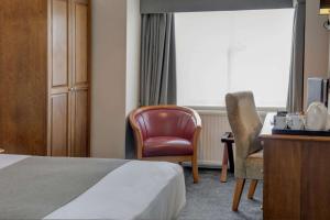 沃克索普Lion Hotel的酒店客房配有一张床、一张桌子和一把椅子。