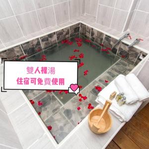 礁溪Meizhou Hot Spring Hotel溫泉商旅的地板上设有带鲜花浴缸的浴室
