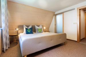 奥泊维森塔尔Haus am Berg - Pension direkt am Skihang的一间卧室配有一张带蓝色和绿色枕头的大床