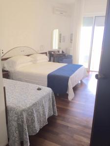 西尼加利亚HR Senigallia, già Hotel Ritz的酒店客房设有两张床和一张桌子。