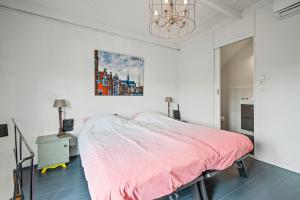 哈莱姆Turfhuys aan het Spaarne的卧室配有一张床,墙上挂有绘画作品