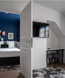 巴黎Hotel Belleval的一间卧室配有一张床,推拉门配有一张床和一张书桌
