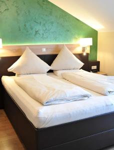 加瑞尔布格克劳斯塔普肯餐厅酒店的一张配有白色床单和枕头的大床
