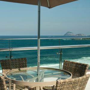 里约热内卢阿瑞纳柯巴卡巴纳酒店的玻璃桌椅,享有海景