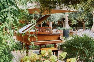 休达德亚Faustino Gran Relais & Chateaux的花园里的钢琴,配有桌椅