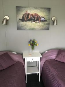ÖlfusStrýta Apartment 2的一间卧室配有两张床和一张桌子,桌子上放着马匹