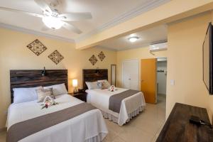 辛普森湾贝克套房酒店的一间带两张床和电视的卧室