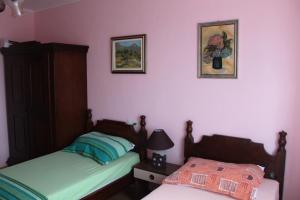 诺瓦利娅Summer house in Novalja的卧室配有两张床,墙上挂有两张照片
