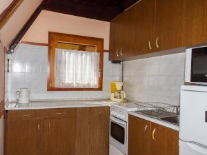 巴拉通马里亚弗都Chalet Kamilla by Interhome的厨房配有木制橱柜和白色的电器