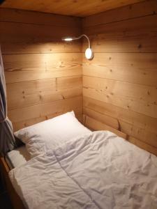 马尼戈Le lodge by Lilou的木墙客房的一张床位