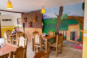 Los Algodones阿尔过多纳庄园酒店的墙上有树壁画的用餐室