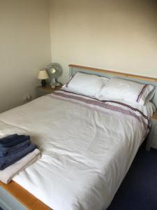 雷特福德JOE'S PLACE的卧室配有白色床和毛巾