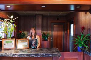 卡内奥赫天堂海湾度假酒店的站在植物房柜台上的女人