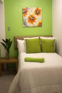 危地马拉Super Precio的一间卧室配有一张带绿色墙壁的床