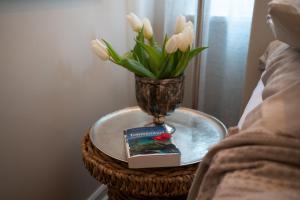 蒂门多弗施特兰德Studio-Apartment Piccolino 26的一张带花瓶、书和鲜花的桌子