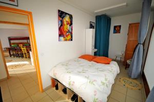 拉格拉沃Gîte le Rocher - Apartment on the ground floor for 8 people的一间卧室配有一张带橙色枕头的床