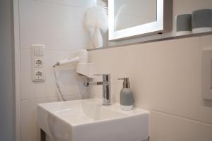 蒂门多弗施特兰德Studio-Apartment Piccolino 26的浴室设有白色水槽和镜子