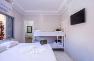 乌巴图巴Eco-Encanto Pousada的白色卧室配有床和平面电视