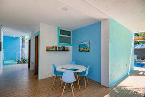 埃斯孔迪多港Casa Menta的一间拥有蓝色墙壁和桌椅的用餐室