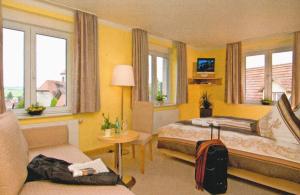 洪堡古尔登罗布雷恩宾馆的酒店客房,设有两张床和一张沙发