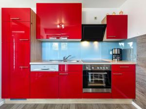 博尔滕哈根Stunning Apartment in Boltenhagen的红色的厨房,配有红色橱柜和水槽