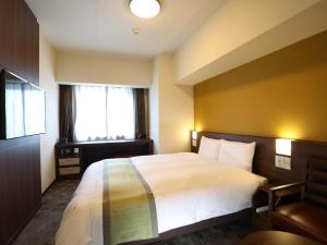东京Dormy Inn Ikebukuro的酒店客房设有床和窗户。