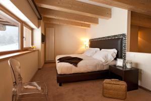帕苏德尔托纳莱天堂大酒店的一间卧室配有一张床、一张桌子和一个窗户。