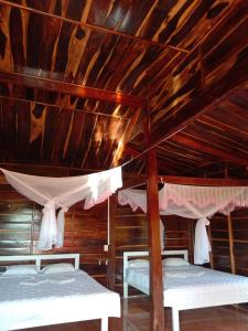 Quan TomRice straw Green lodge- resort的配有木天花板的客房设有两张床。
