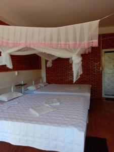 Quan TomRice straw Green lodge- resort的一间卧室配有一张带天蓬的大床