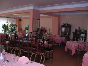 法尔科纳拉·玛里提马阿尔伯吉奥腾达佛得角酒店的用餐室配有桌椅和粉红色的桌布