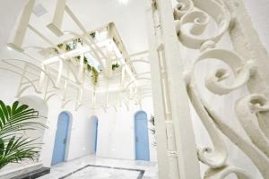 科尼尔-德拉弗龙特拉La Casa del Arco的走廊上设有白色的墙壁和蓝色的门