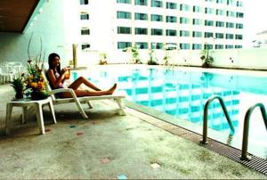 合艾合艾丽景湾酒店的坐在游泳池旁椅子上的女人