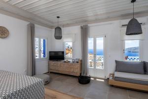 阿斯提帕莱亚镇Luxury Apartment in the Heart of Astypalaia的一间卧室配有一张床、一张沙发和窗户。