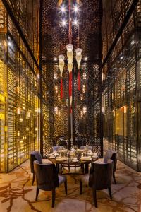 天津天津梅江中心皇冠假日酒店的一间带桌椅和吊灯的用餐室