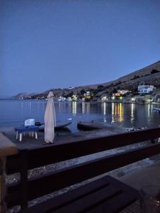 锡米Symi . VILLA CALME (Sur la Mer).的一张桌子,上面有雨伞和船上